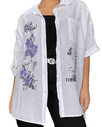 Chemise blanche pour femme avec imprimé floral mauve avec camisole noire et ceinture argent métallisée.