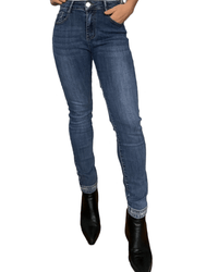 Jeans skinny pour femme avec brillants dans le bas avec bottillons noirs.