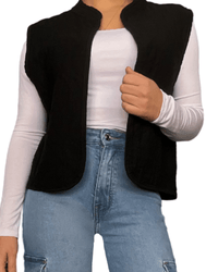 Veste noire sans manches style rembourré pour femme avec chandail blanc.