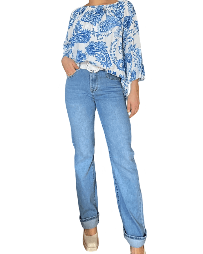 Blouse blanche pour femme avec imprimé de Paisley bleu avec jeans.