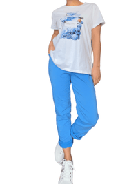 T-shirt blanc avec imprimé de roses bleues pour femme avec pantalon et sneakers.