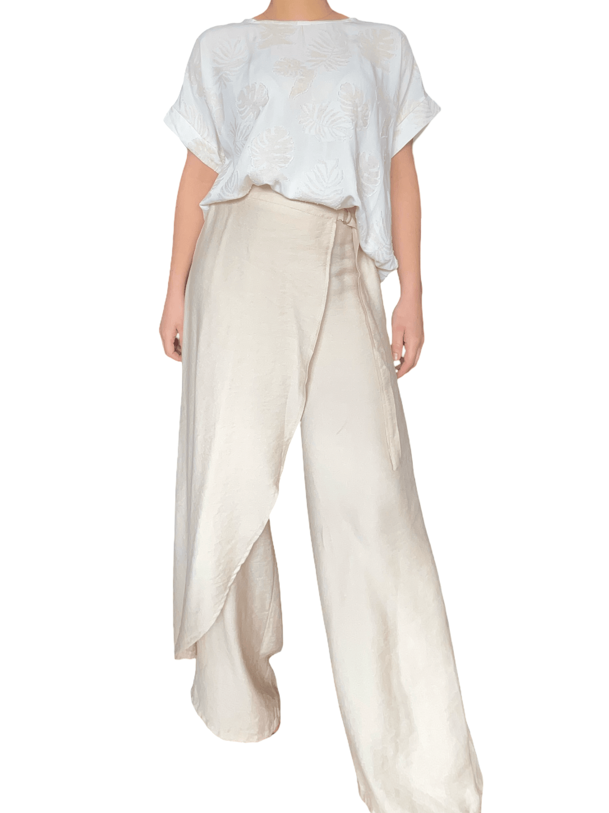 T-shirt blanc crème à motifs de feuilles beiges pour femme avec pantalon chic.