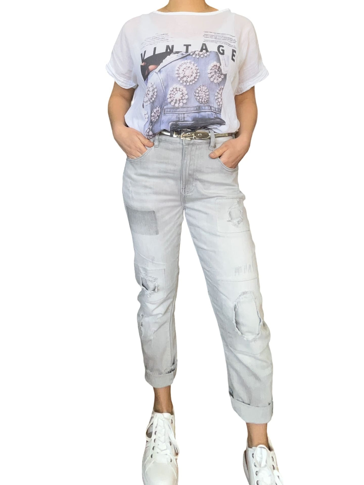 T-shirt blanc avec imprimé vintage pour femme avec pantalon gris et sneakers.
