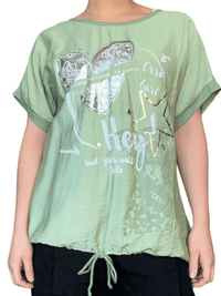 T-shirt vert pâle avec imprimé d'un cœur argenté pour femme.