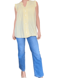 Camisole jaune boutonnée pour femme avec jeans.