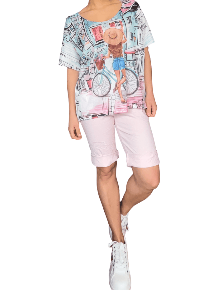 T-shirt pour femme avec imprimé d'une femme et son vélo avec bermuda et sneakers.