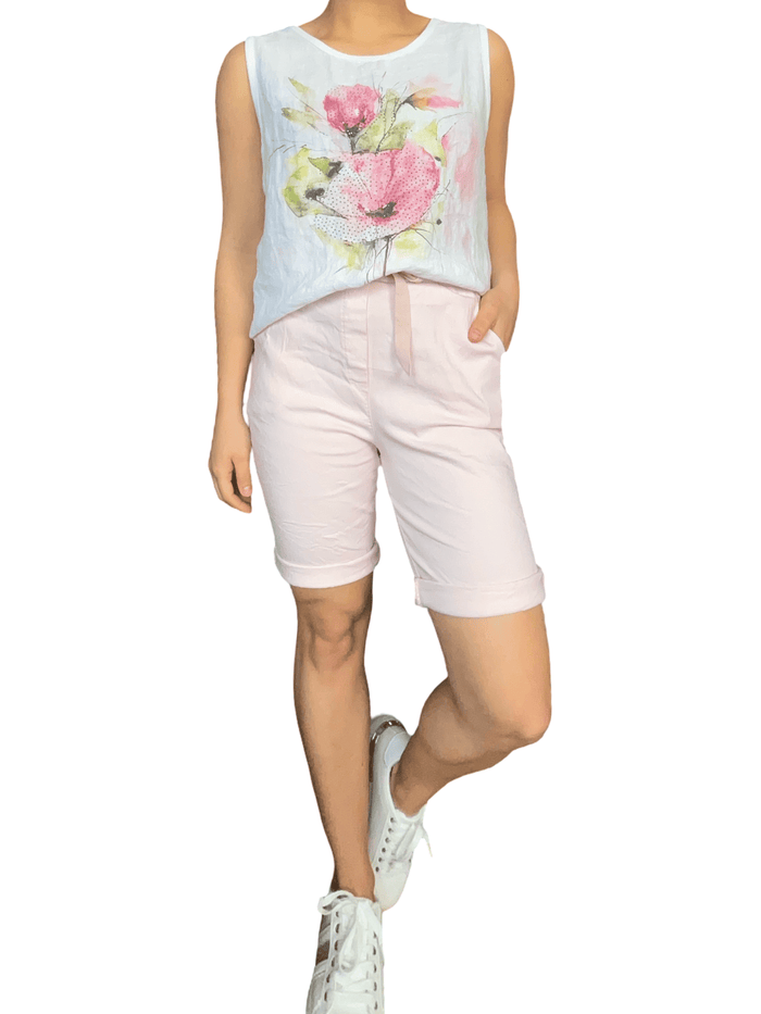 Camisole blanche pour femme avec imprimé d'une fleur avec bermuda et sneakers.