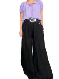 Blouse lilas à motifs floraux brodés pour femme avec pantalon noir.