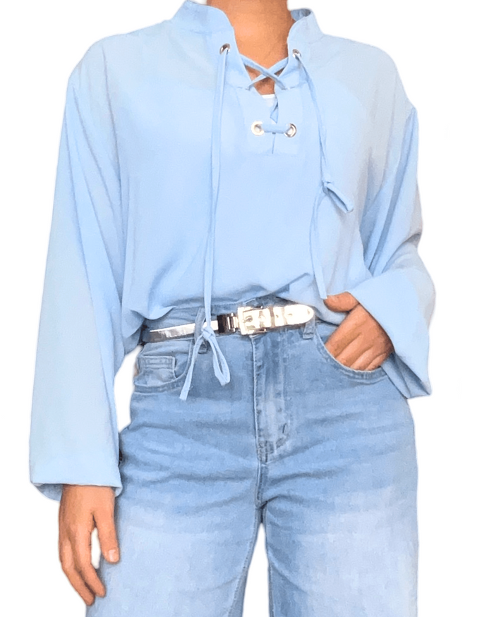Blouse à lacets bleu ciel pour femme avec ceinture métallisée.