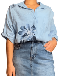 Chemise bleue pour femme avec imprimé de grandes fleurs bleues.