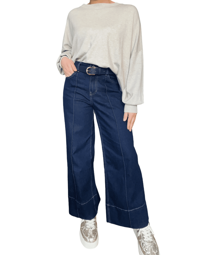 Chandail beige uni à manche longue pour femme avec ceinture et jeans.