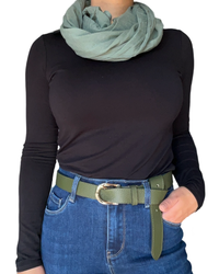 Chandail à manche longue noir pour femme avec foulard vert et ceinture verte.