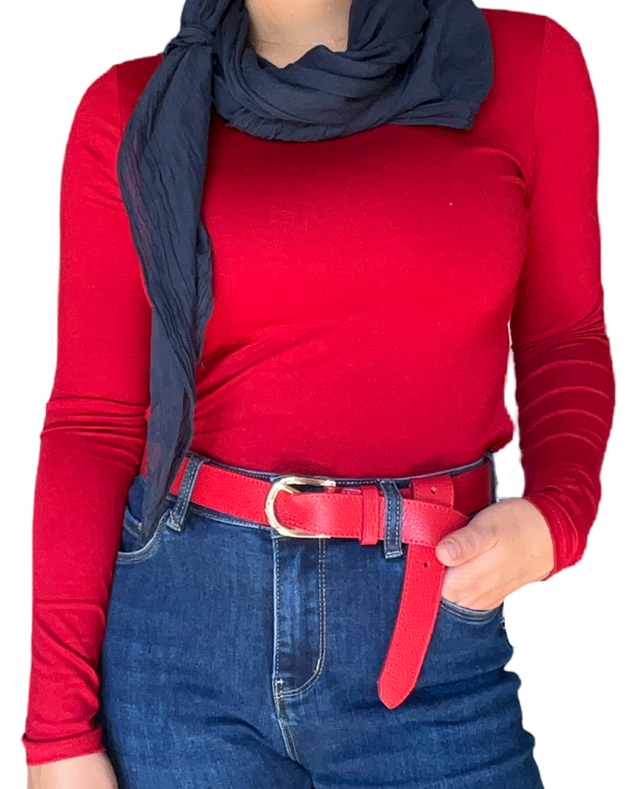 Chandail à manche longue rouge pour femme avec foulard bleu marin et ceinture rouge.