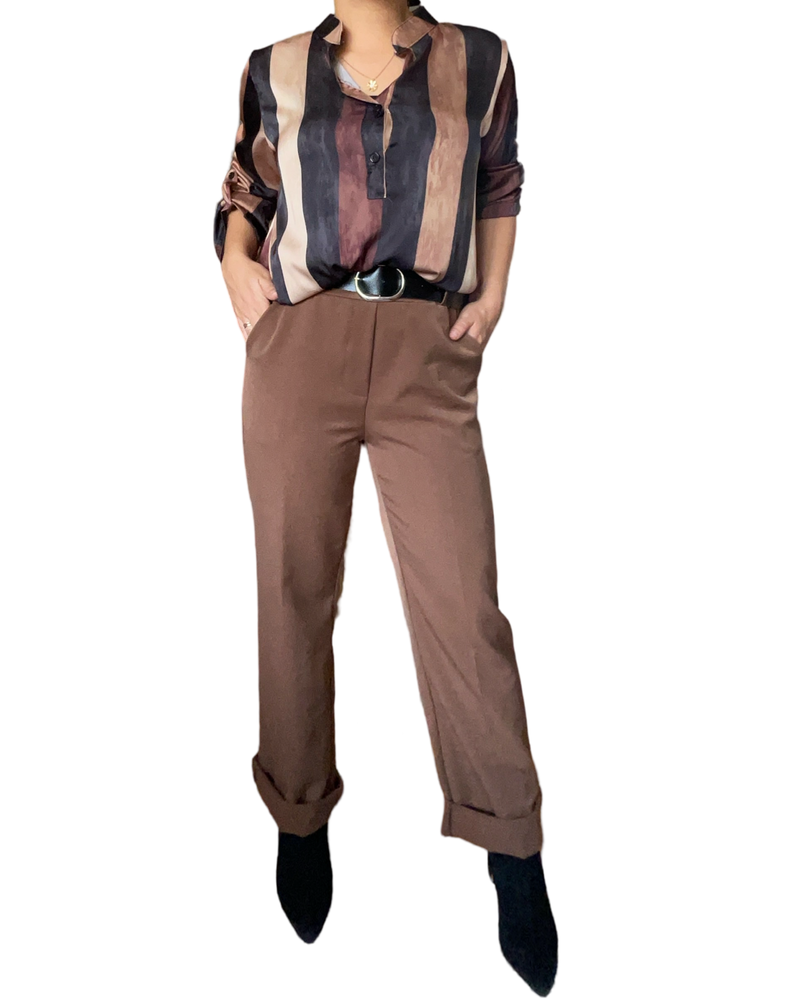 Blouse rayée brun et noir pour femme avec pantalon et bottillons.