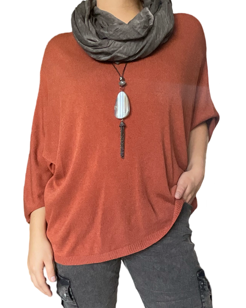 Chandail orange rouille à manche 3/4 pour femme avec foulard et collier long.