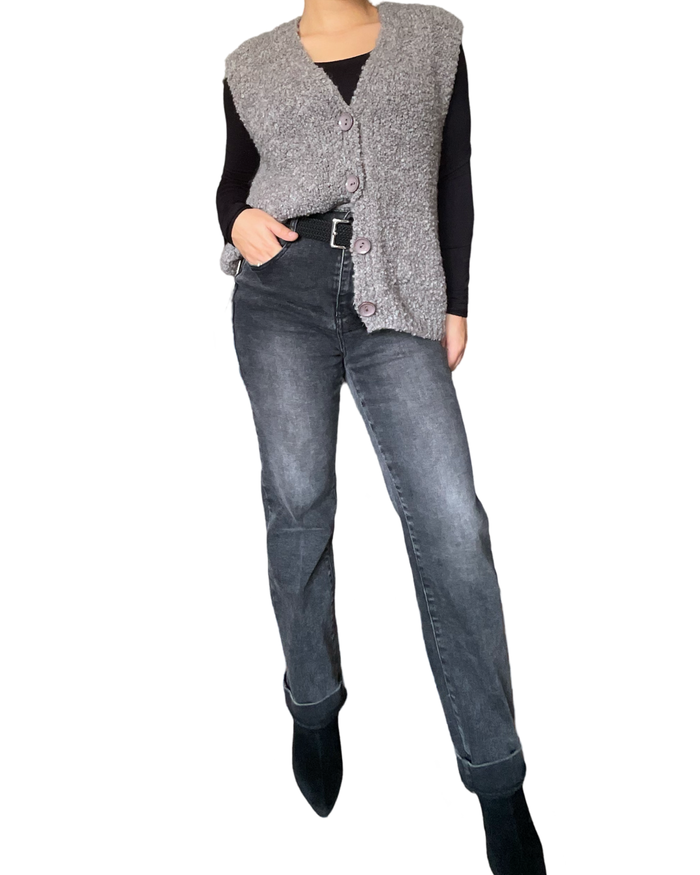 Veste grise sans manches pour femme avec ceinture, jeans et bottillons.