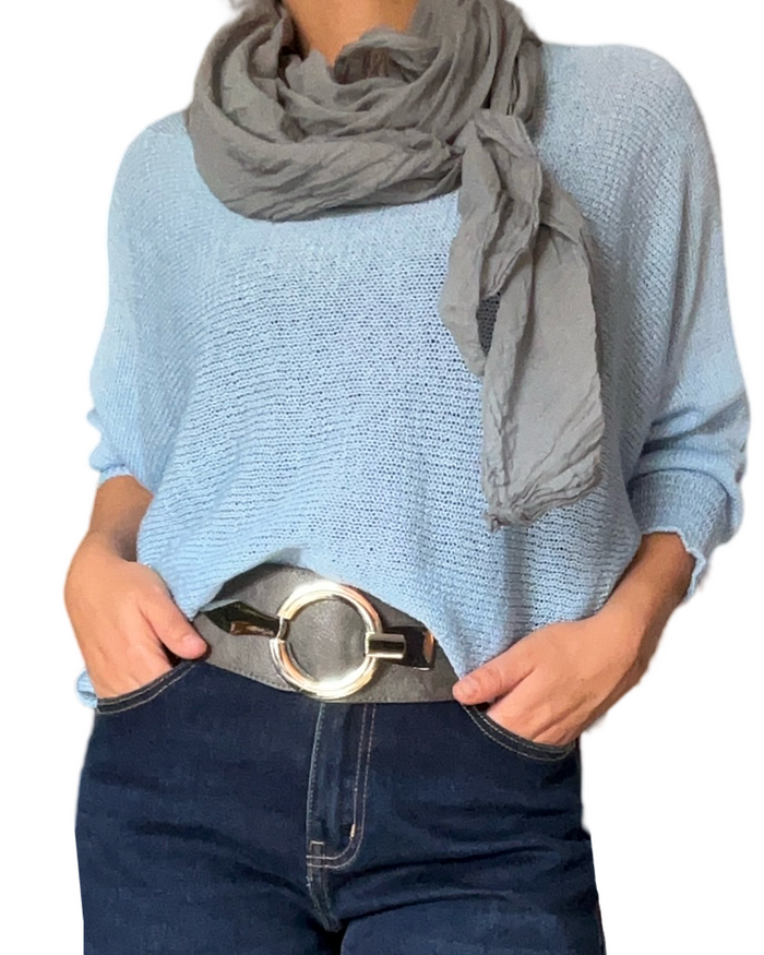 Chandail en mailles bleu ciel pour femme avec foulard gris et ceinture grise.