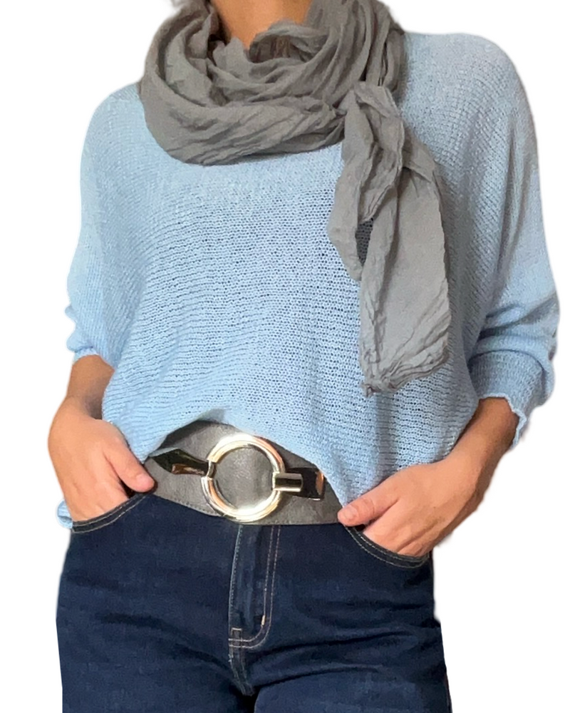 Chandail en mailles bleu ciel pour femme avec foulard gris et ceinture grise.