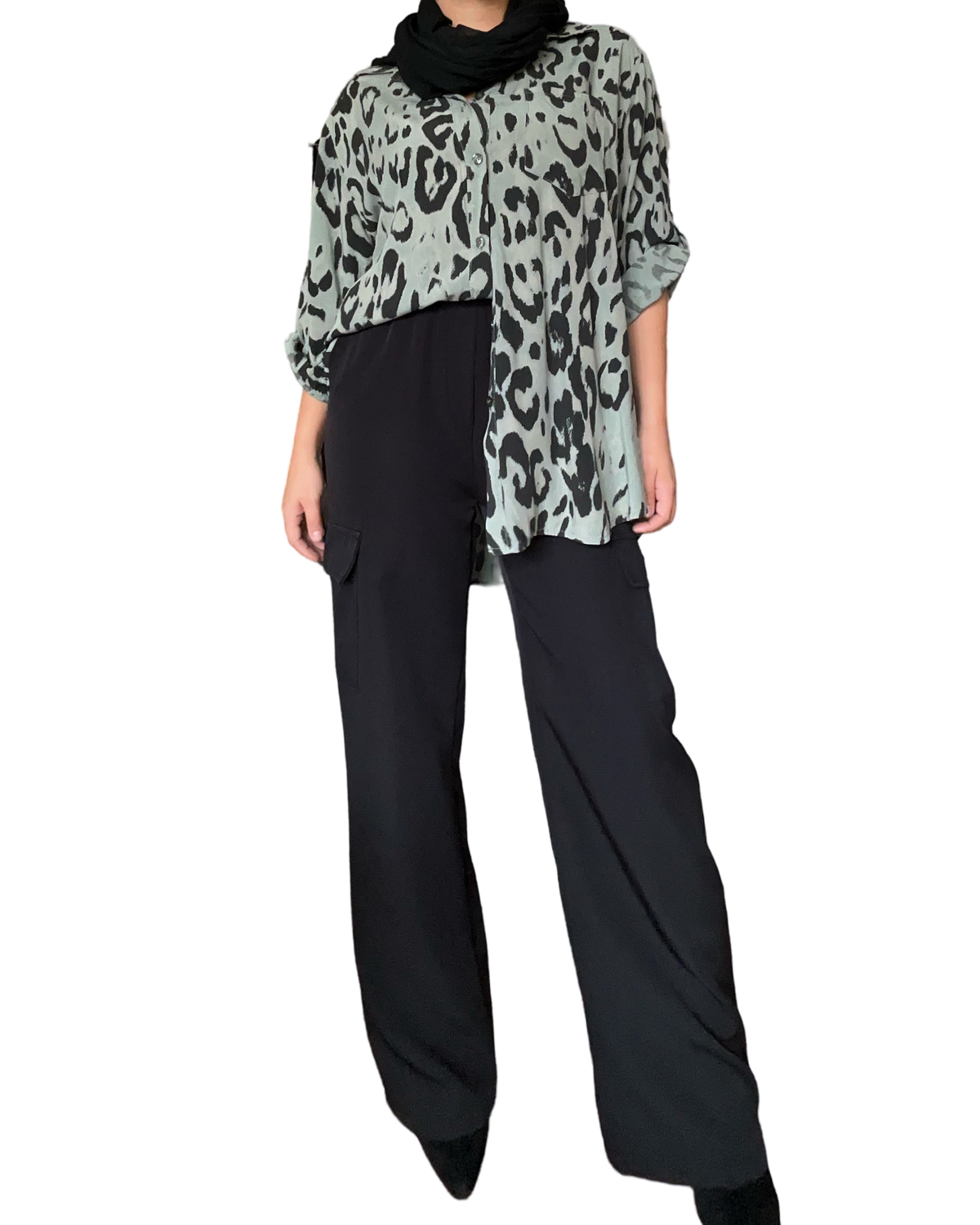 Chemise verte pour femme avec imprimé animal print avec pantalon noir et bottillons noirs.