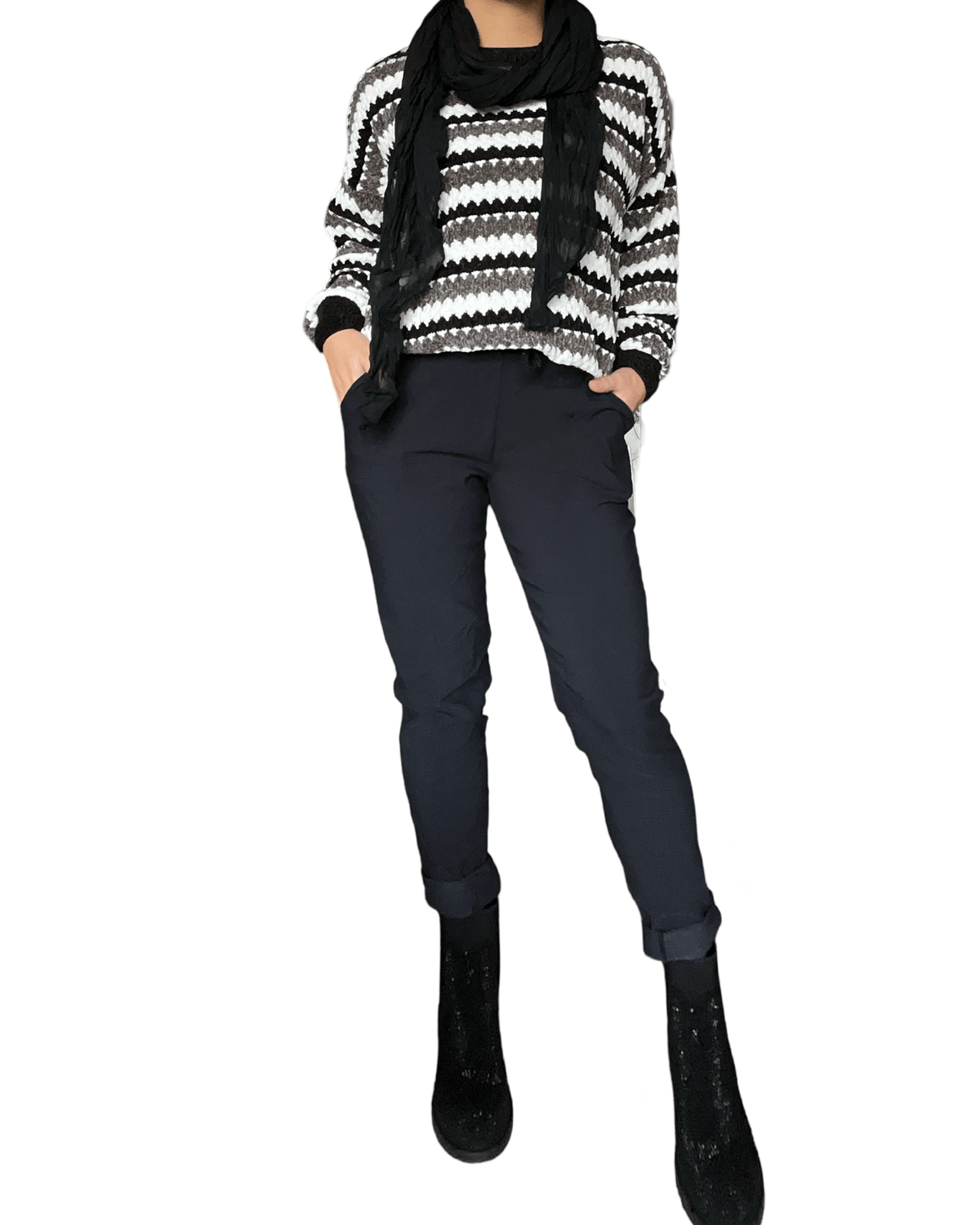 Chandail rayé noir, blanc et gris pour femme avec pantalon noir et bottillons sport. 