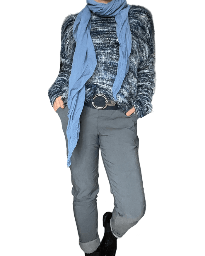 Chandail bleu bleu en tricot doux à manche longue pour femme avec ceinture et pantalon gris. 