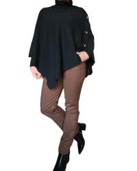 Chandail noir style poncho pour femme avec pantalon brun et bottillons noirs. 