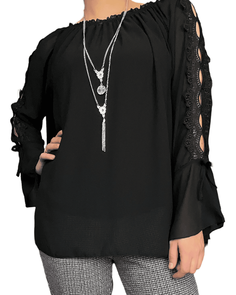 Blouse noire à manche longue évasée pour femme avec collier long. 