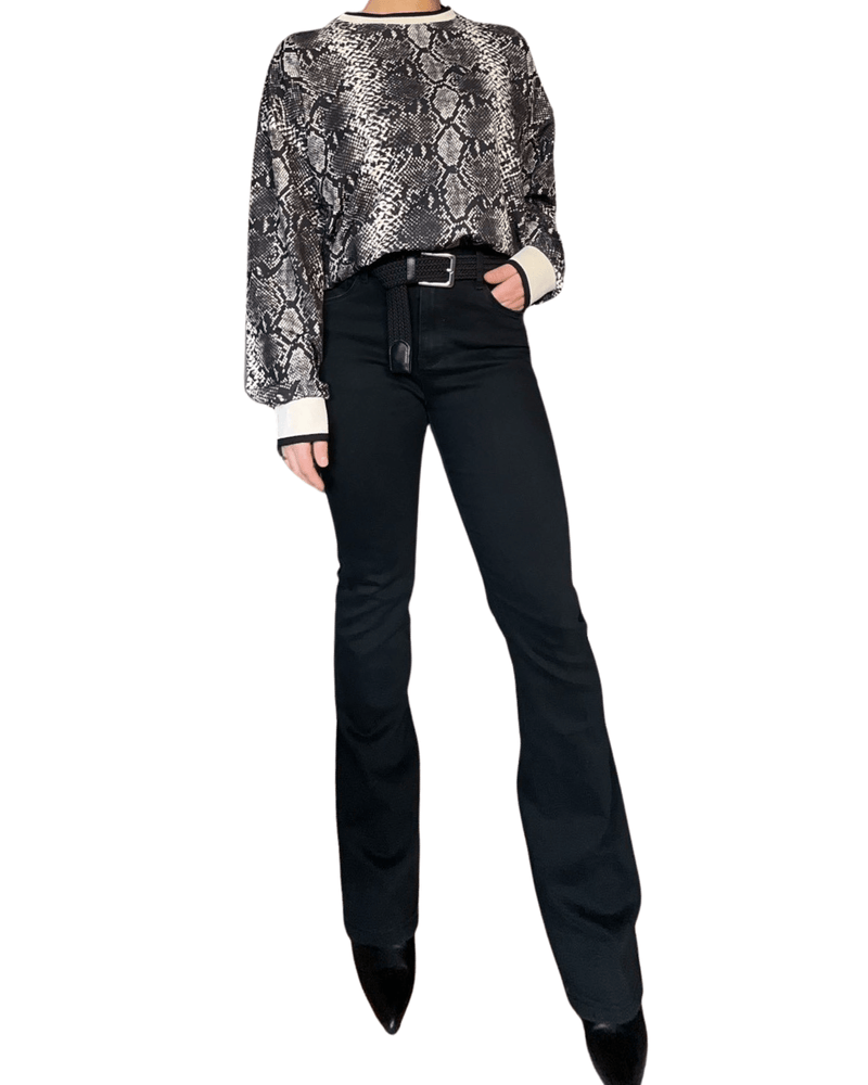 Pantalon flare noir pour femme avec chandail et ceinture.