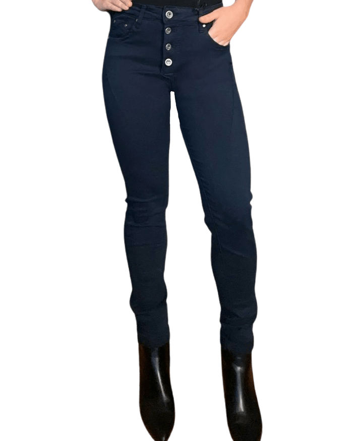 Jeans skinny bleu marin pour femme avec bottillons noirs.