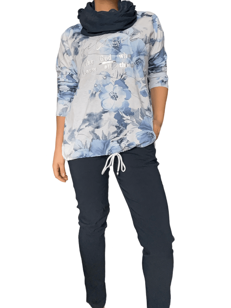 Chandail blanc avec imprimé floral bleu pour femme avec pantalon.