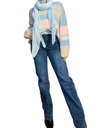 Chandail bleu en tricot rayé rose et beige pour femme avec jeans et bottillons et foulard.