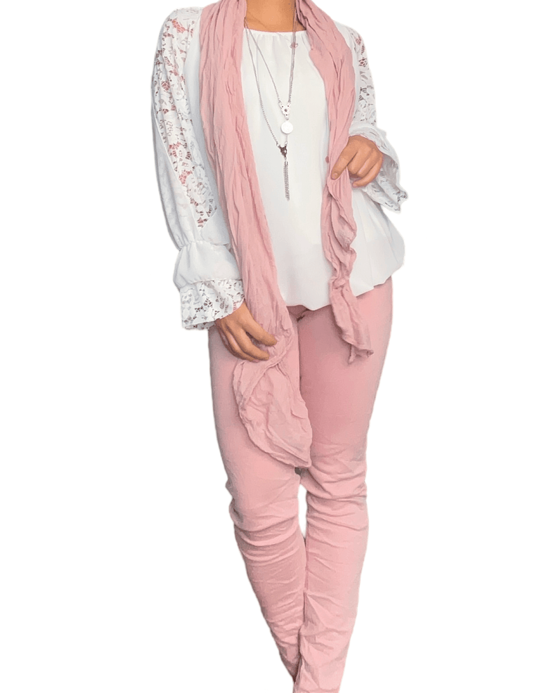 Blouse blanche à manches longues pour femme avec foulard rose pâle et pantalon rose.