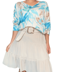 Chandail blanc cassé avec imprimé floral bleu pour femme avec jupe.