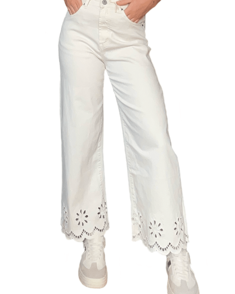 Pantalon blanc droit évasé blanc crème pour femme avec sneakers.