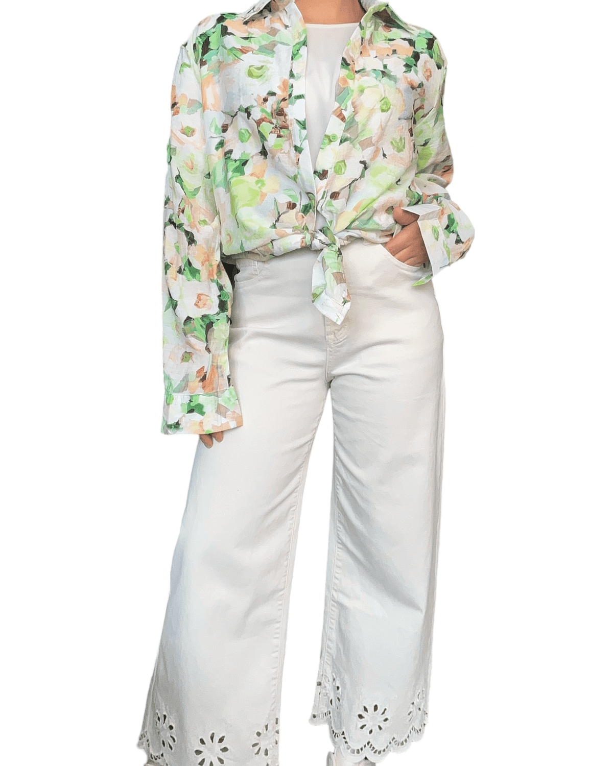 Chemise avec imprimé floral vert et beige pour femme avec pantalon blanc.