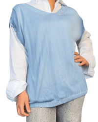 T-shirt bleu sans manches pour femme avec chemise blanche en dessous. 