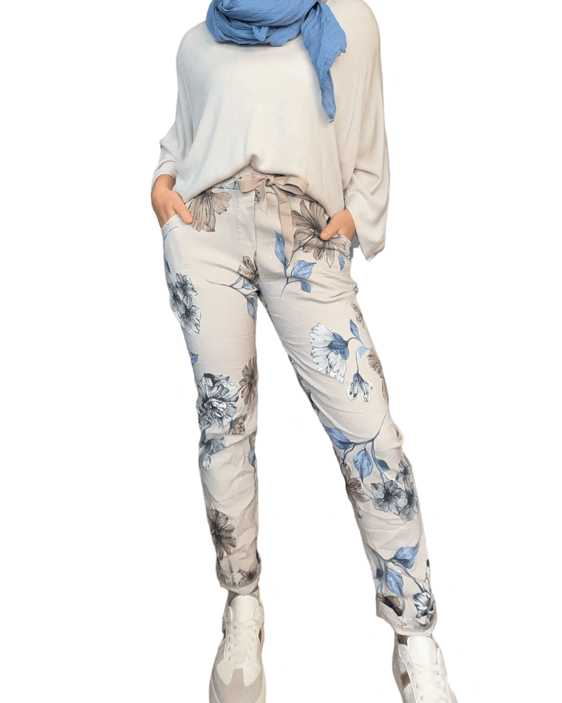 Pantalon beige à taille élastique pour femme avec imprimé floral avec foulard, chandail et sneakers. 