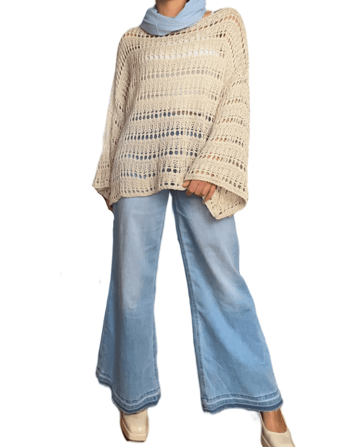 Chandail beige en grandes mailles avec jeans ample.