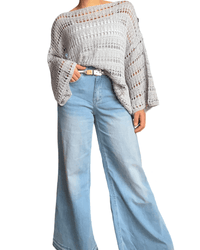 Chandail gris en grandes mailles pour femme avec jeans ample.