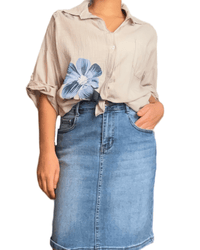 Chemise beige pour femme avec imprimé de grandes fleurs bleues et jupe de jeans.