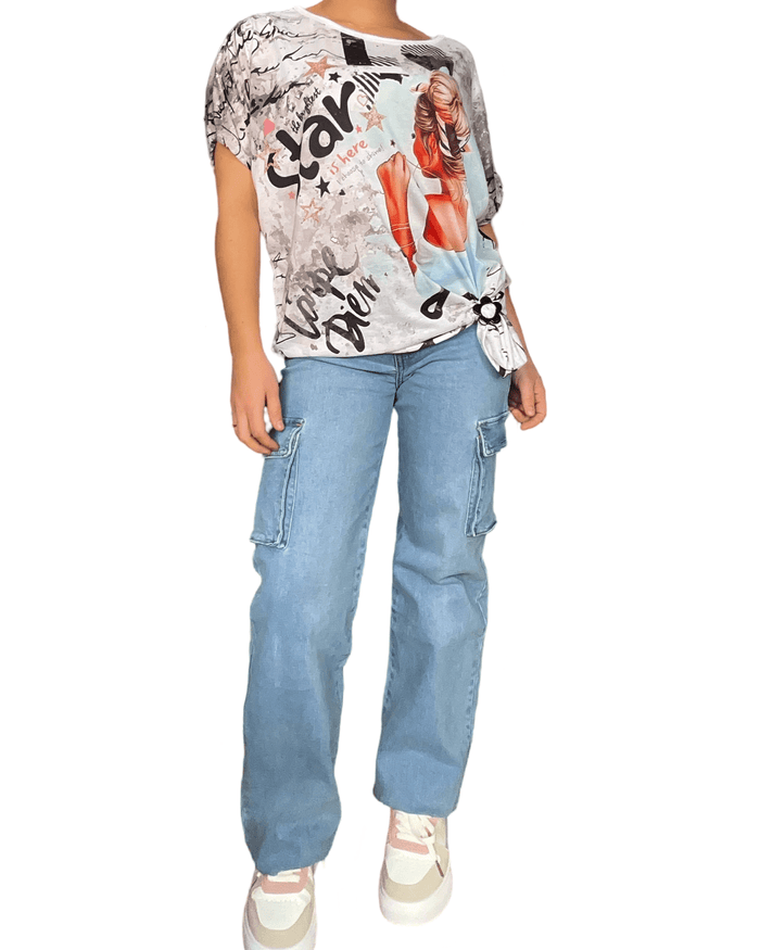 T-shirt blanc femme avec imprimé d'une femme avec jeans cargo et sneakers.