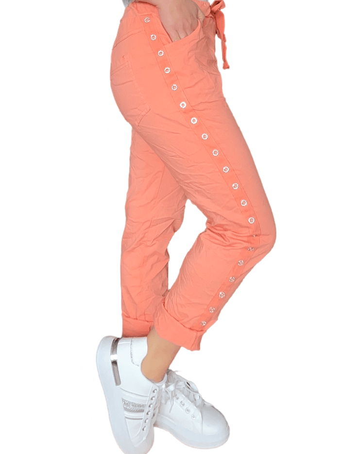 Pantalon orange à taille élastique avec cordon pour femme avec sneakers.