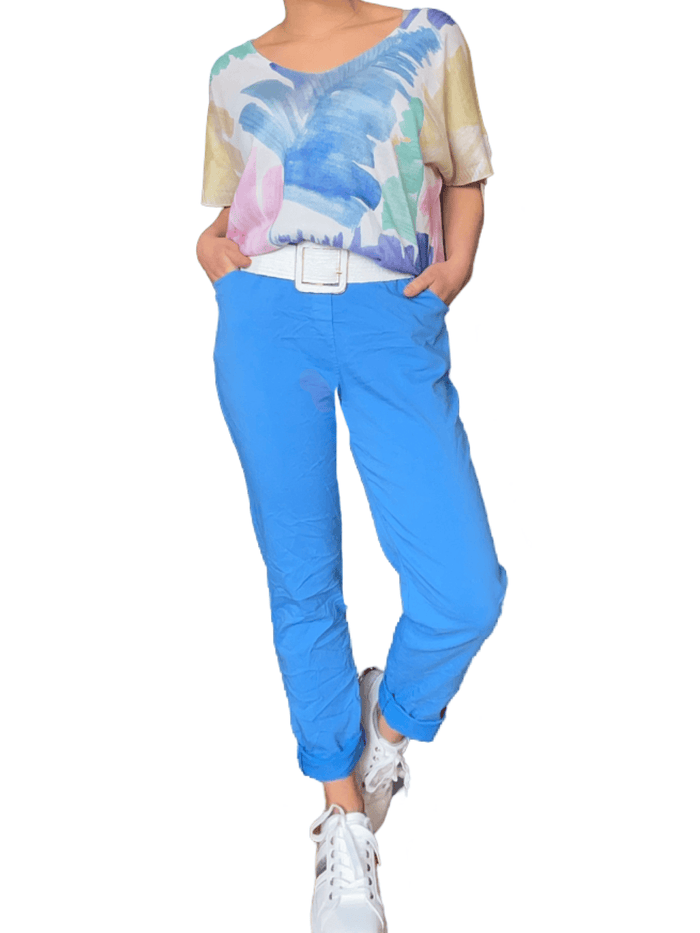 T-shirt avec imprimé de feuilles abstraites pour femme avec pantalon et sneakers.