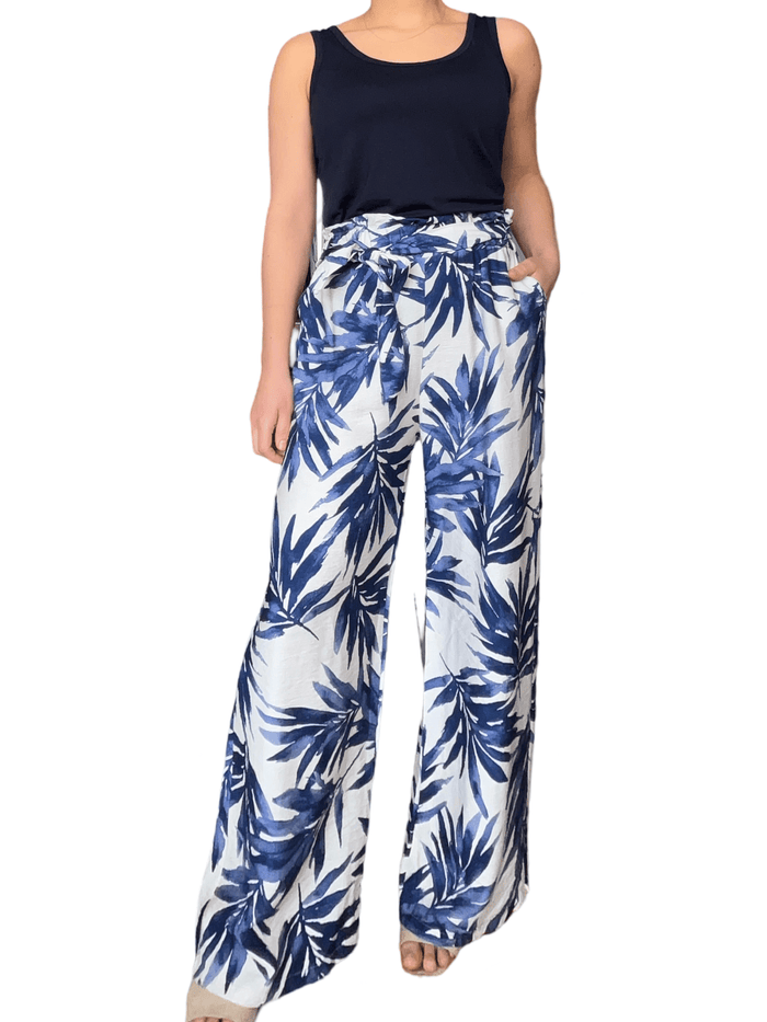 Pantalon blanc palazzo avec imprimé de feuilles bleues pour femme avec camisole marine.