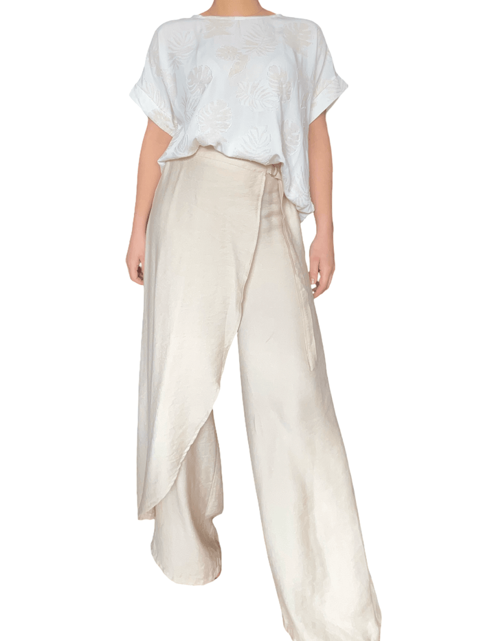 T-shirt blanc crème à motifs de feuilles beiges pour femme avec pantalon chic.