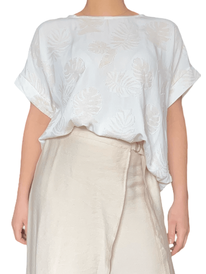 T-shirt blanc crème à motifs de feuilles beiges pour femme.