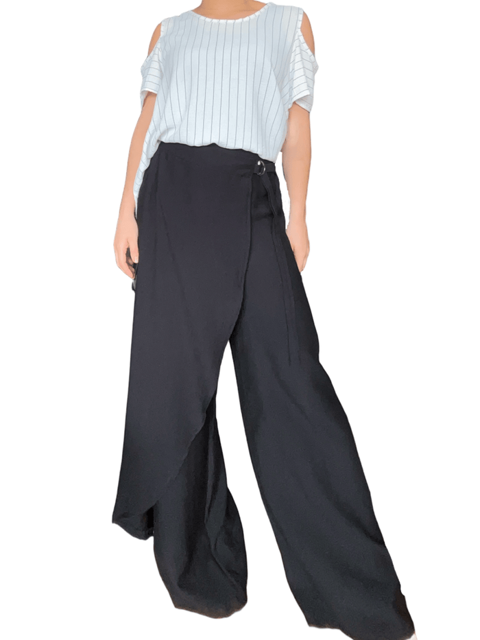 Chandail blanc rayé noir à ouverture sur l'épaule pour femme avec pantalon chic.