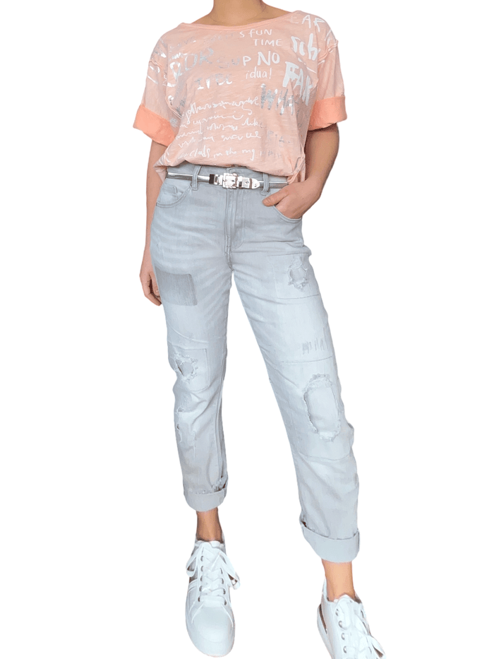 T-shirt saumon pour femme avec imprimé d'écritures avec ceinture métallique et sneakers.