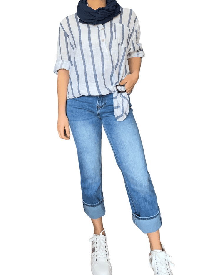 Blouse blanche à rayures marines pour femme avec jeans et sneakers.