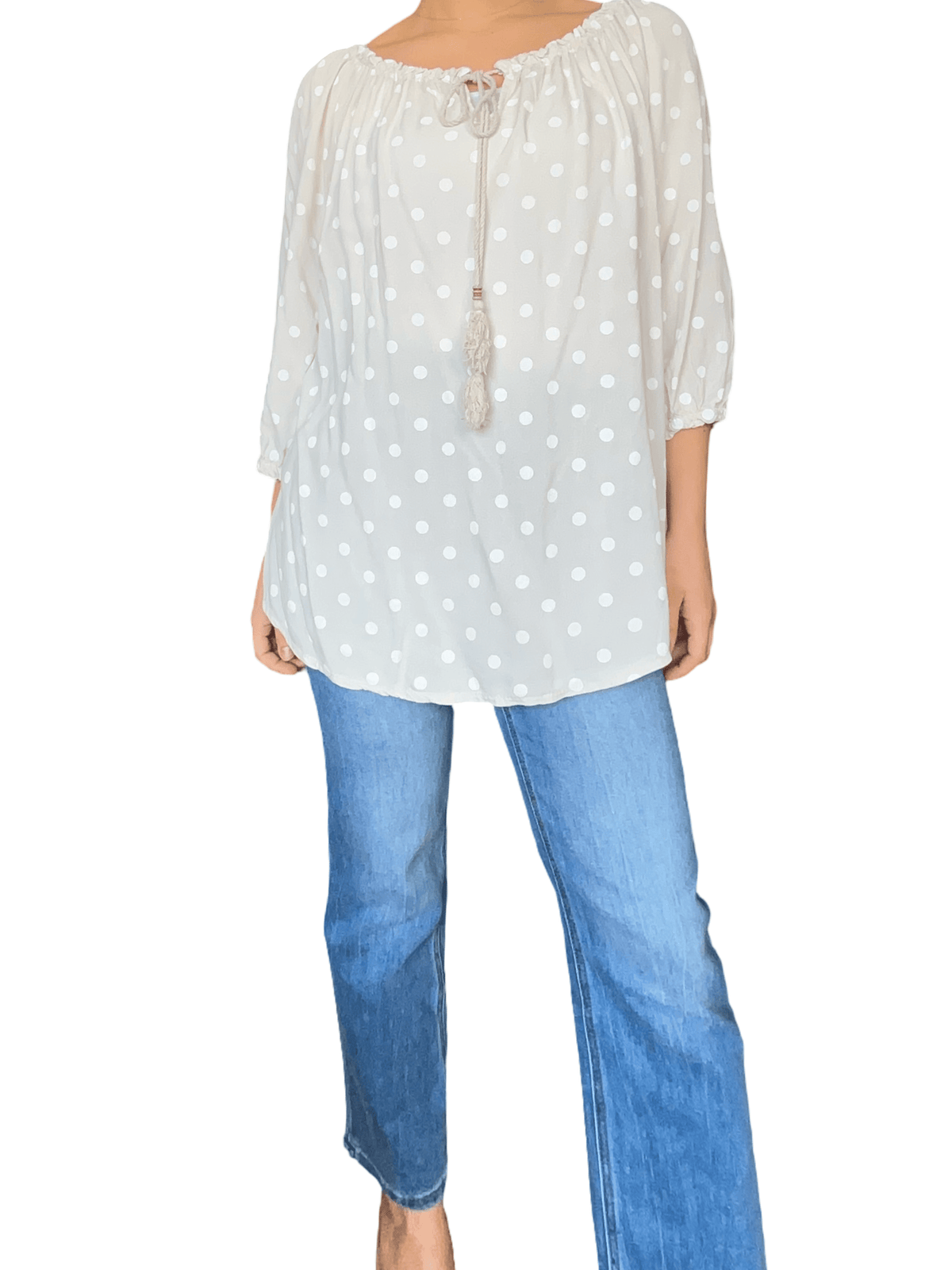Blouse beige à motifs de pois blancs pour femme avec jeans.
